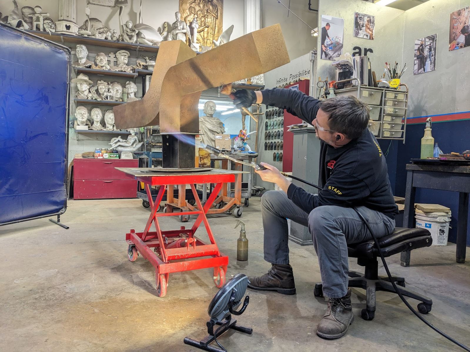 a patina being applied to a bronze sculpture by our patina technician at our facility