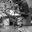 Technician repairing damaged sections of the cast bronze lamp fixture during restoration treatment.