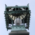 This photo shows the Chinese Lanterns before the conservation treatment.  There are missing elements on the cast bronze lanterns, broken glass (Later in research we discovered that the cast bronze lanterns had German crystal on the side panels.).