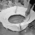 The plaster casing, that which holds the silicon rubber in place, is being cleaned before going to the wax department.