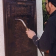 The memorial bronze plaque was restored and hot patinaed to a traditional museum rich brown tone. The letters were highlighted and a hot wax treatment performed on site after installation upon the granite pedestal. Notice our head conservator performing the hot wax treatment.